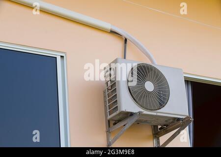 Square VAC Air Conditioning Unit on wall house with a round fan. Stock Photo