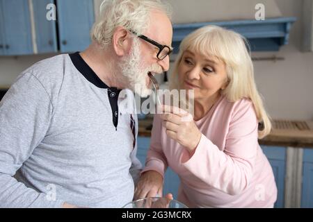 Elderly couple having fun in kitchen. Stock Photo