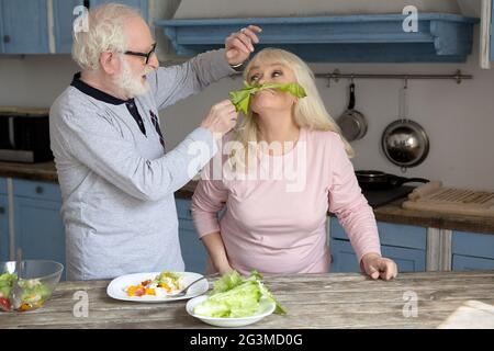 Elderly couple having fun in kitchen. Stock Photo