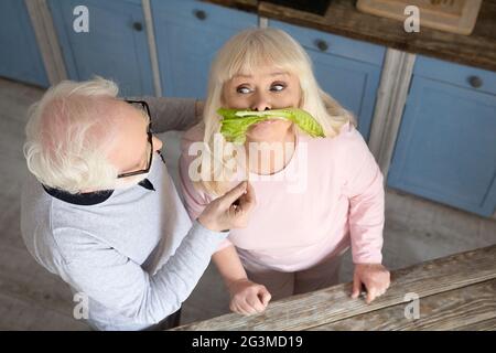 Elderly couple having fun in kitchen. Stock Photo
