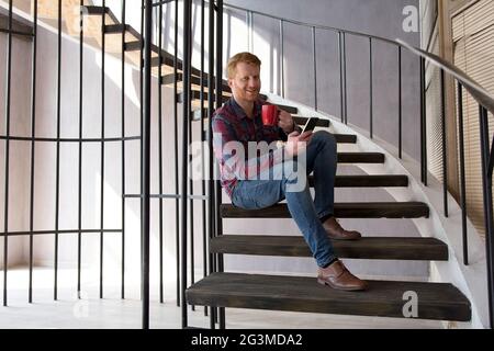 Good looking man sitting on steps. Stock Photo