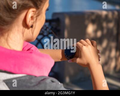 Photo of a young woman checks her pulse after the race. Stock Photo