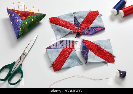 Sewing process of patchwork block, pincushion, quilting and sewing accessories. Stock Photo