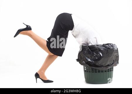 Woman stuck in trash bin with her head. Stock Photo