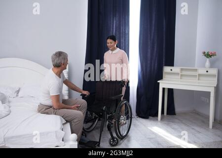 Nurse assisting disabled man. Stock Photo