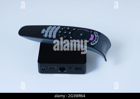 TV box black box with remote control. White background. Stock Photo