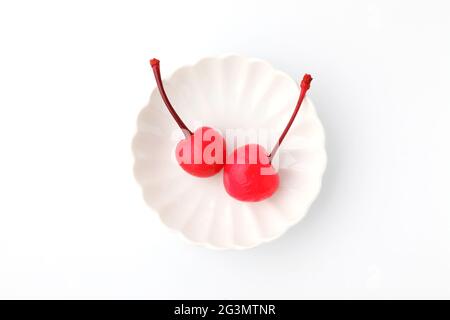 canned red cherries in syrup on plate isolated on white background Stock Photo