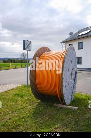 '16.04.2021, Rheinbach, North Rhine-Westphalia, Germany - Internet broadband expansion, construction site laying of fibre optic cable, cable drum with Stock Photo