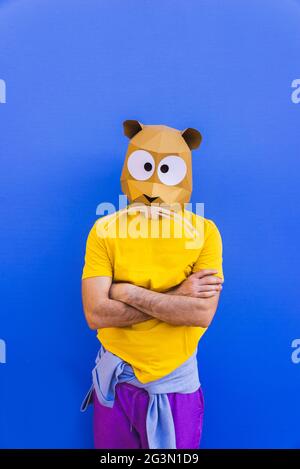 Cool man wearing 3d origami mask with stylish colored clothes - Creative concept for advertising, animal head mask doing funny things on colorful back Stock Photo