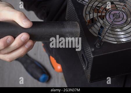Cleaning the computer power supply from dust with a brush Stock Photo