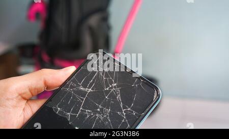 Phone with broken screen cracked, with abstract background close up Stock Photo