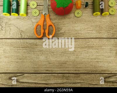 Top view of sewing tools on wooden background with copy space Stock Photo
