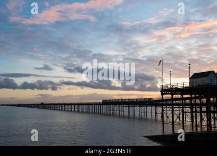 Southend-on-Sea pier with train and early evening sky across calm water Stock Photo