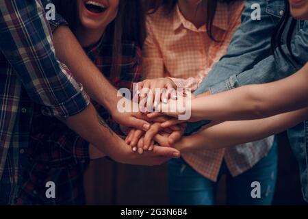 Close up top view of people putting their hands together Stock Photo