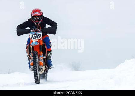 Russia Vyborg 02.23.2021 motorcyclist in red helmet rides on the road in winter Stock Photo