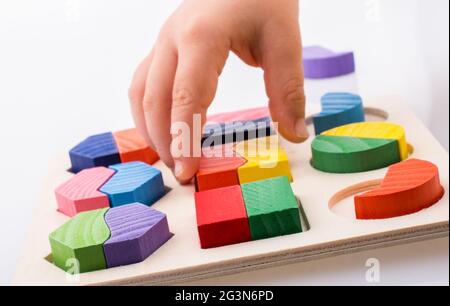 Colorful pieces of a logic puzzle in hand Stock Photo