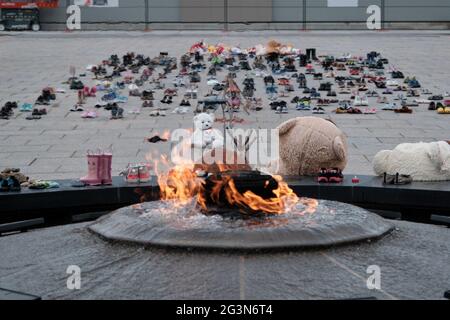 Memorial to 215 aboriginal children whose remain found Residential School. Toys and shoes left. in front of Centennial Flame of Ottawa Parliament Stock Photo