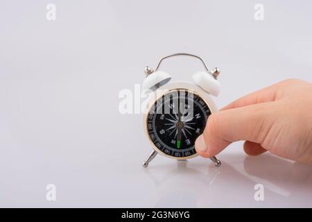Child holding a compass on an alarm clock Stock Photo