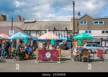 Salcombe town Devon, view of people drinking and eating at tables outdoors in the harbour area of Salcombe, Devon, England, UK Stock Photo