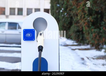 Eco friendly transport concept. Electric vehicle charger station installed in parking lot. Close up. Stock Photo
