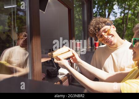 Happy attractive young couple romantically eating a fresh pizza outdoors. Stock Photo