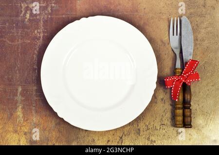 Festive table setting. Plate and cutlery tied with red ribbon Stock Photo