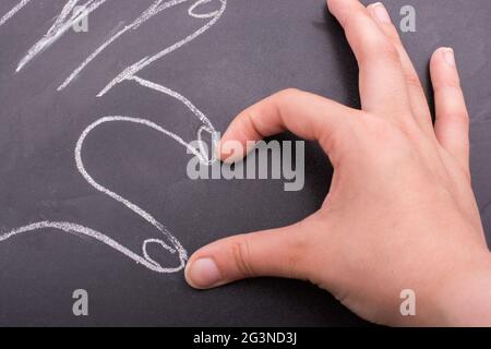 Hands forming a heart on blackboard Stock Photo