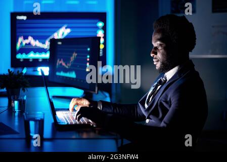 African American employee typing on laptop in workspace Stock Photo