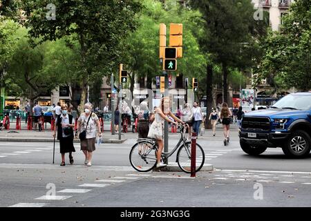 Young woman on bicycle waiting at the traffic lights, Barcelona, Spain. Stock Photo
