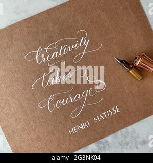 Creativity takes courage - beautiful quote made with pointed pen and white ink calligraphy on the kraft paper Stock Photo