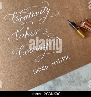 Creativity takes courage - beautiful quote made with pointed pen and white ink calligraphy on the kraft paper Stock Photo