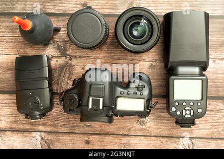 collection of camera equipment including digital camera body and lenses pictured from above on a wooden background Stock Photo