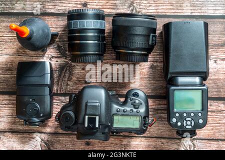 collection of camera equipment including digital camera body and lenses pictured from above on a wooden background Stock Photo