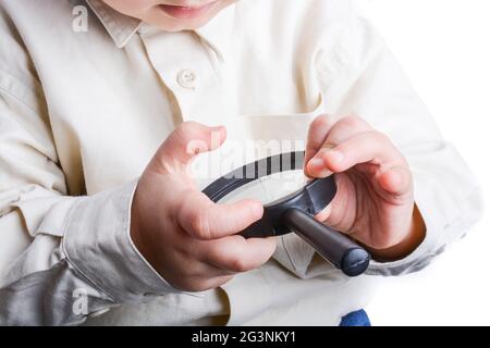 Baby holding a magnifying glass in hand on a white background Stock Photo