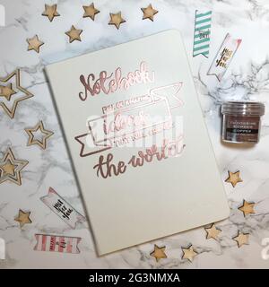 Notebook full of amazing ideas that wil change the world - hot embossing copper on white cover in calligraphy Stock Photo