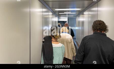 Sanford, FL USA - May 13, 2021:   People waiting in the jetway to board an Allegiant airplane at the Sanford International Airport in Sanford, Florida Stock Photo