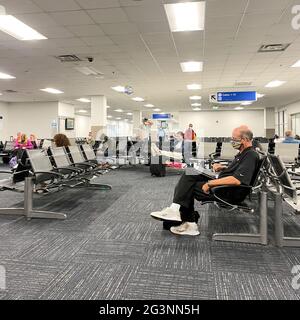 Sanford, FL USA - May 13, 2021:   People waiting in the gate area to board a planes at the Sanford International Airport in Sanford, Florida. Stock Photo