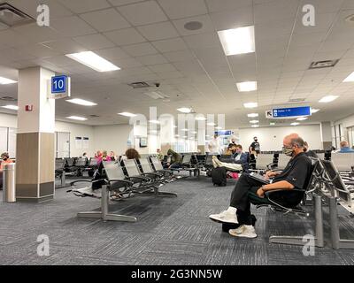 Sanford, FL USA - May 13, 2021:   People waiting in the gate area to board a planes at the Sanford International Airport in Sanford, Florida. Stock Photo