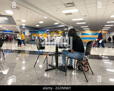 Sanford, FL USA - May 13, 2021:   People waiting in the gate area to board a planes at the Sanford International Airport in Sanford, Florida. Stock Photo