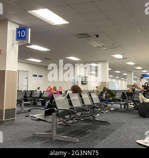 Sanford, FL USA - May 13, 2021:   People waiting in the gate area to board a planes at the Sanford International Airport in Sanford, Florida. Stock Photo