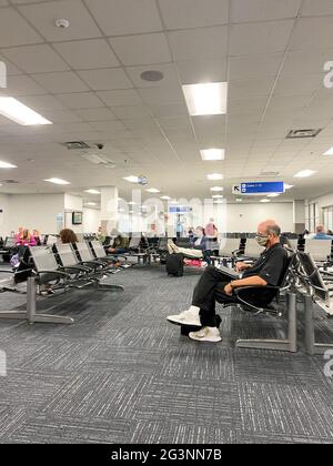 Sanford, FL USA - May 13, 2021:   People waiting in the gate area to board a planes at the Sanford International Airport in Sanford, Florida. Stock Photo