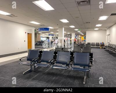 Sanford, FL USA - May 13, 2021:   People waiting in the gate area to board a planes at the Sanford International Airport in Sanford, Florida. Stock Photo