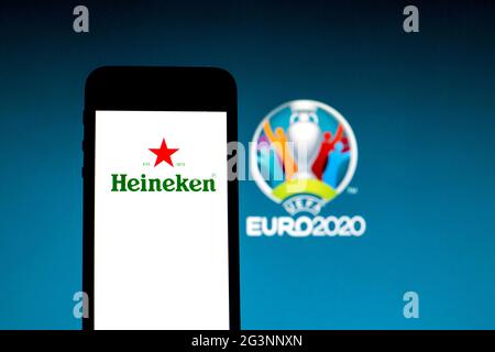 In this photo illustration a Heineken logo seen displayed on a smartphone with a UEFA Euro 2020 logo in the background. Stock Photo
