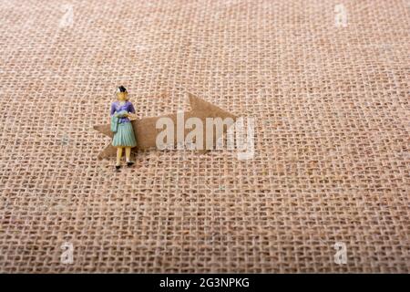 Figurine woman led by an arrow on canvas Stock Photo