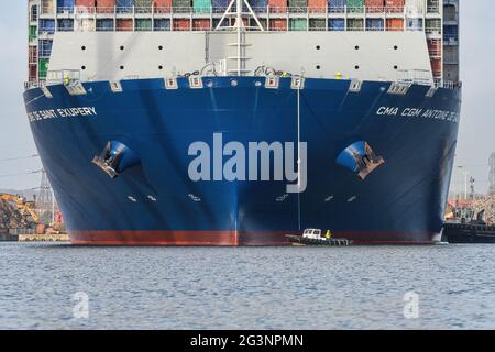 A port services vessel takes lines from the container ship CMA CGM Antoine de Saint Exupery as it berths at the Port of Southampton - March 2018 Stock Photo