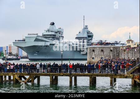 Large crowds line view points around Portsmouth Harbour as the  Royal Navy aircraft carrier HMS Queen Elizabeth departs for her maiden operational dep Stock Photo