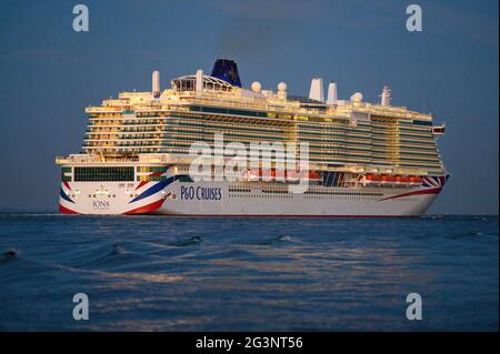 A moody dusk view of P&O Cruises' LNG-powered cruise ship Iona as it passes Calshot Spit on Southampton Water - June 2021 Stock Photo