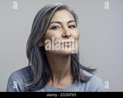 Charming Asian mature woman smiles at camera Stock Photo