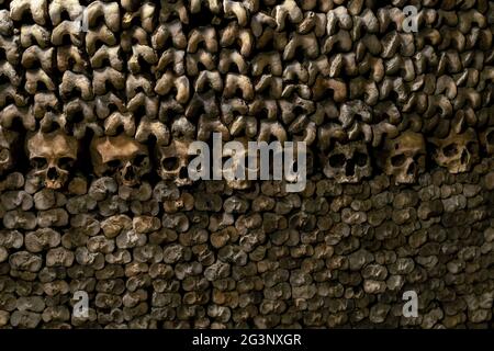 Wall made of Skulls and Bones in the Catacombs of Paris, France Stock Photo