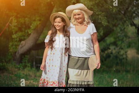 Grandmother And Granddaughter Are Standing In The Beautiful Garden Stock Photo